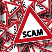 Red warning signs with text "SCAM"